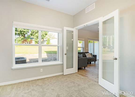A room with a large window and a view of a backyard.