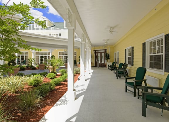 a long porch with rocking chairs and a gardenat Arbor Oaks at Lakeland Hills, Florida