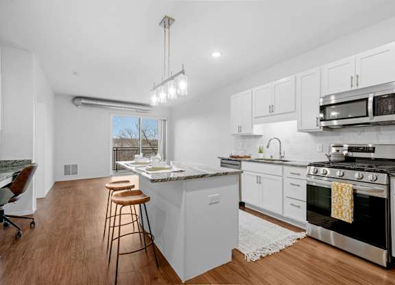 A kitchen with white cabinets and a black stove top oven.