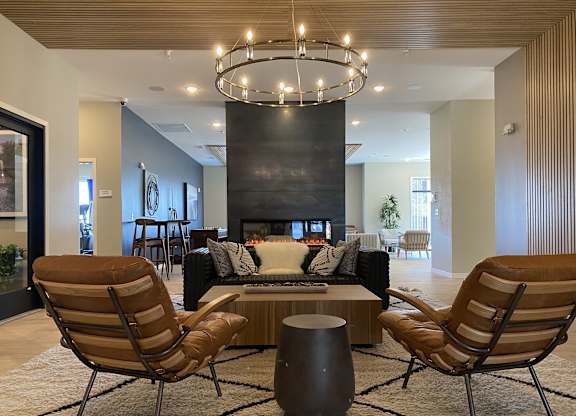a large living room with a fireplace and a chandelier