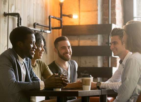 Four people sitting at a table in a cafe.