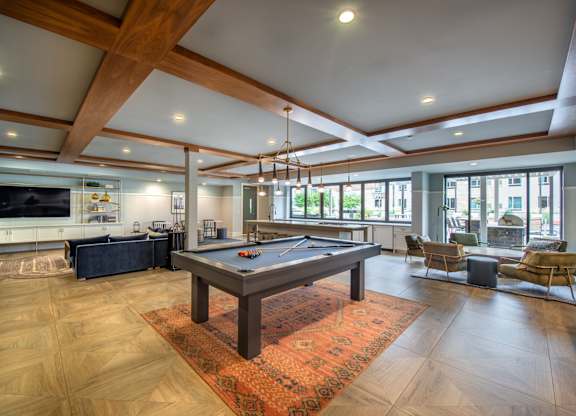 a game room with a pool table in the center of it