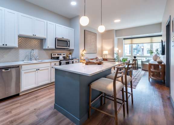a large kitchen with a blue island and a dining room