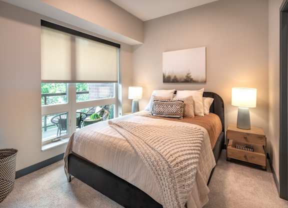 a bedroom with a bed and a large window