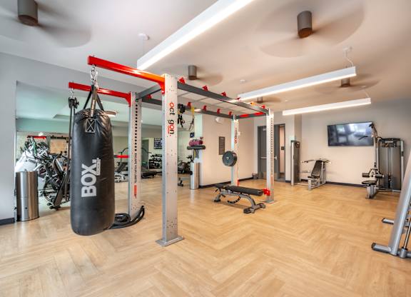a gym with a punching bag and weights on the floor