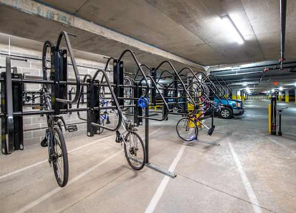 a row of bikes on racks in a parking garage