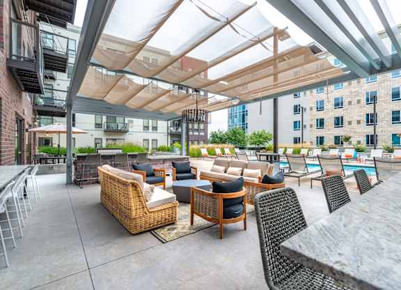 a patio with couches tables and chairs and a pool