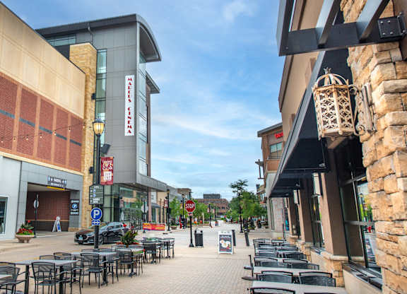 a city street with tables and chairs in front of a building