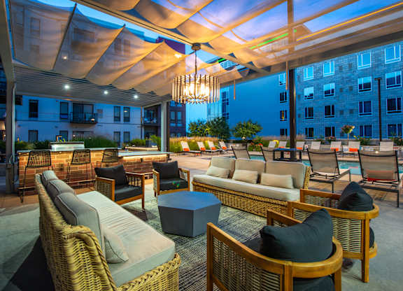 a patio with couches and chairs and a chandelier