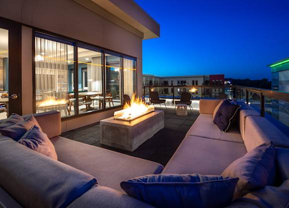 a living room with couches and a fire pit