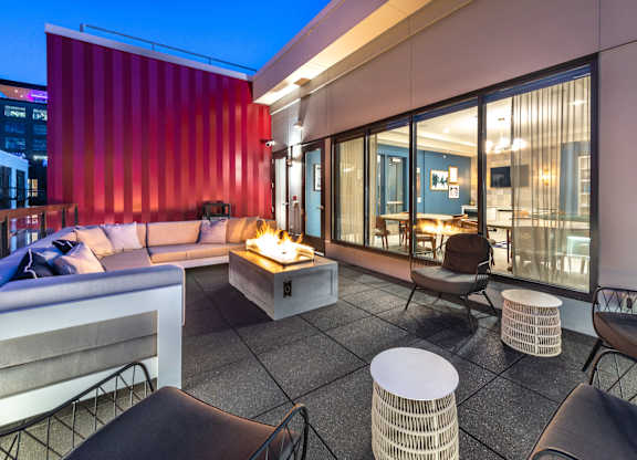 a lounge area with couches and chairs and a fire pit