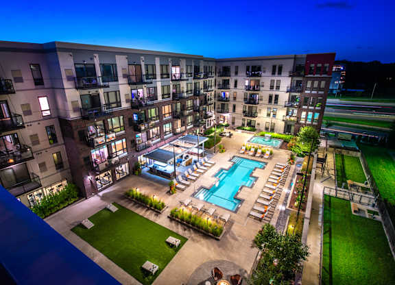 an overhead view of an apartment complex with a pool at night
