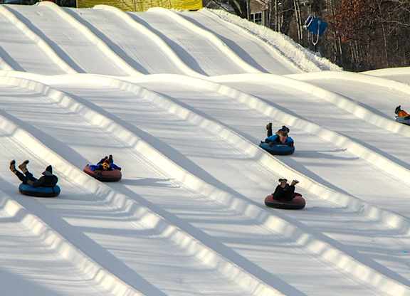 a group of people snowboarding down a snow covered slope