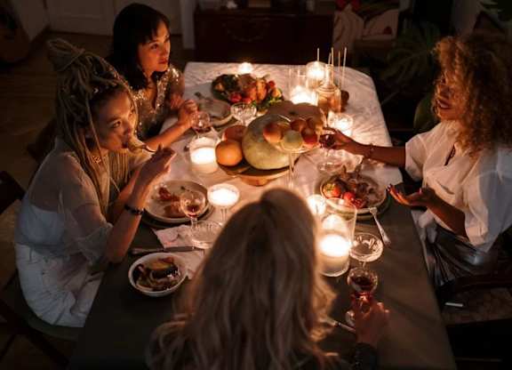 a group of women sitting around a table eating dinner