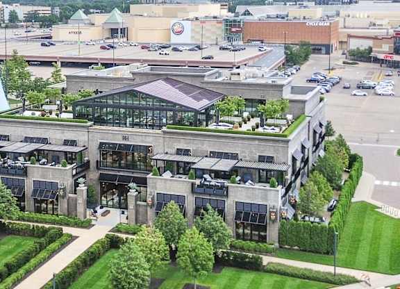 an aerial view of a building with a green roof and a parking lot