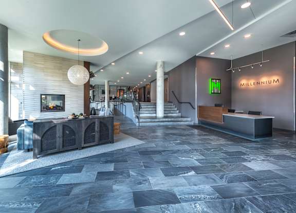 the lobby of a hotel with a fireplace and a reception desk