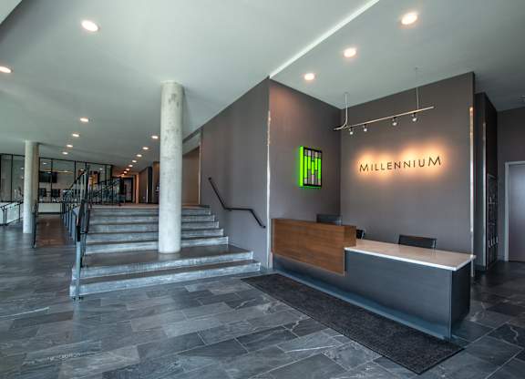 a lobby with a reception desk and a staircase
