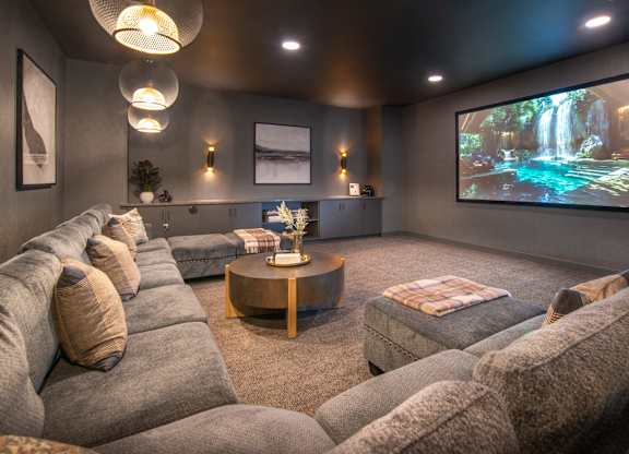 a large screening room with couches and a large screen tv