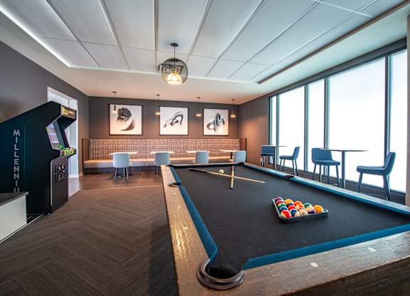 a game room with a pool table and a large window
