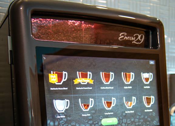 a coffee maker with a coffee cup in front of it