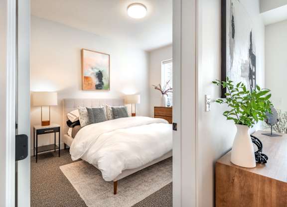 a bedroom with a bed and a vase with a plant