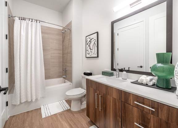 a bathroom with a large mirror and a toilet and a shower