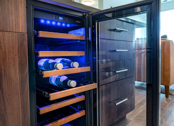 a wine refrigerator with bottles in it in a living room