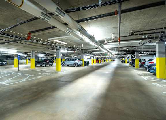 a parking garage with cars and yellow columns