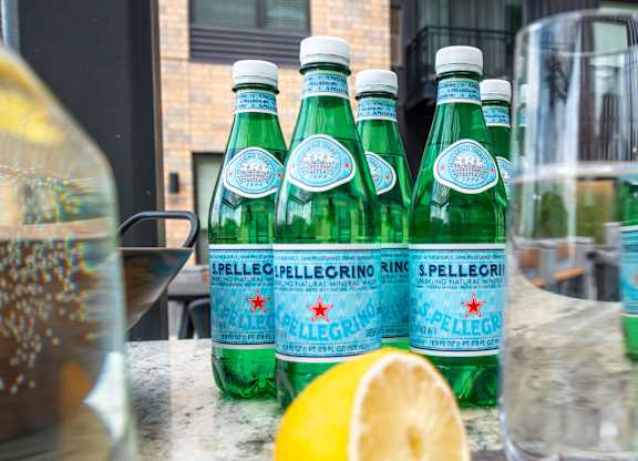 a group of bottles of sparking water and a lemon on a counter