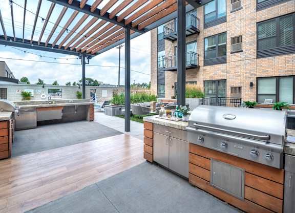 a large outdoor kitchen with stainless steel appliances and a pergola