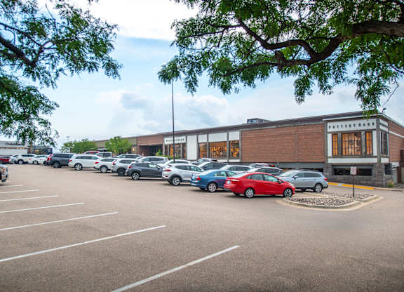 a parking lot full of cars in front of a building
