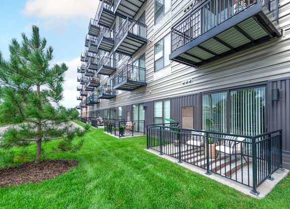 the private balconies of an apartment building with grass and trees