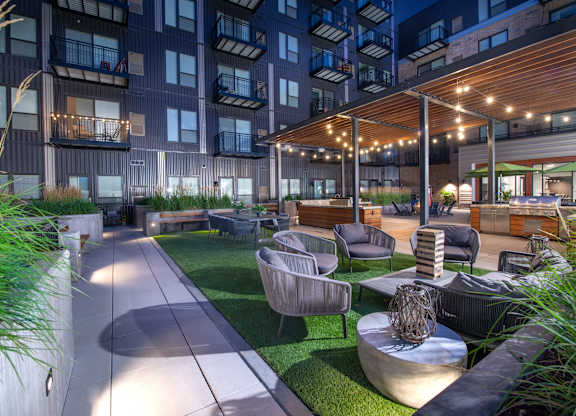 a rendering of a patio area with tables and chairs in an apartment building