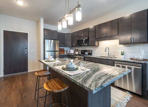 a kitchen with stainless steel appliances and a marble counter top