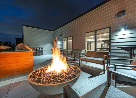 a fire pit on the patio of a home at night