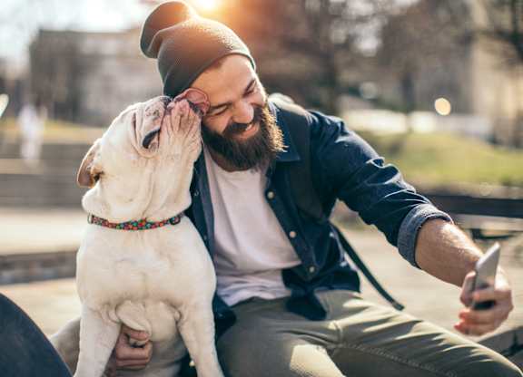 a man sitting on a bench with his dog
