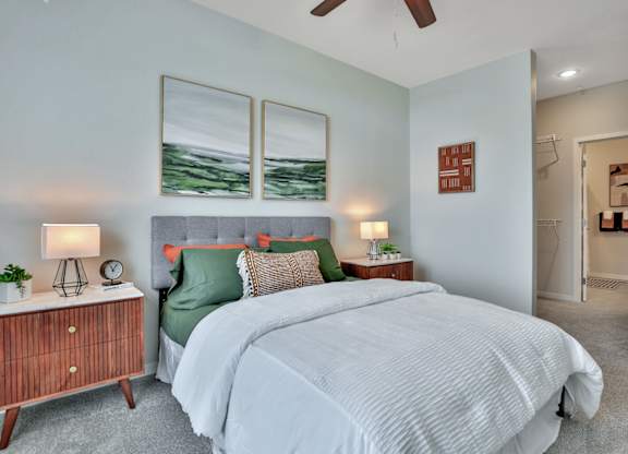 A bedroom with a large bed and a wooden nightstand.