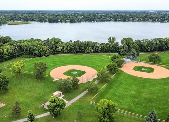 a baseball field with a lake in the background