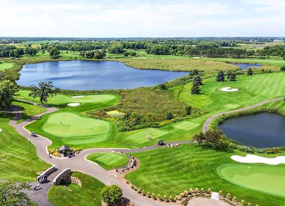 an aerial view of a golf course and a lake