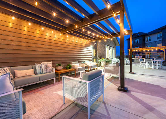 a patio with couches and tables under a wooden deck