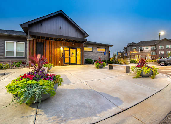the entrance to a home with a driveway and potted plants