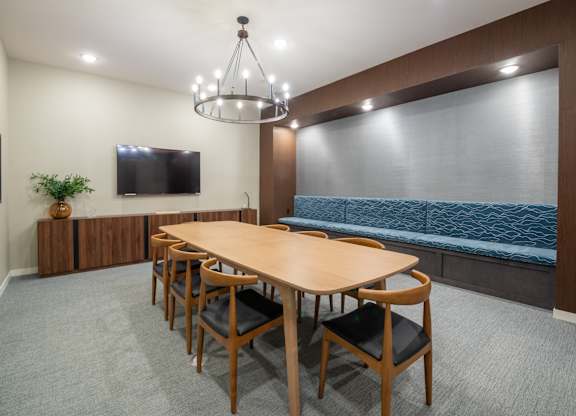 a conference room with a wooden table and chairs and a tv