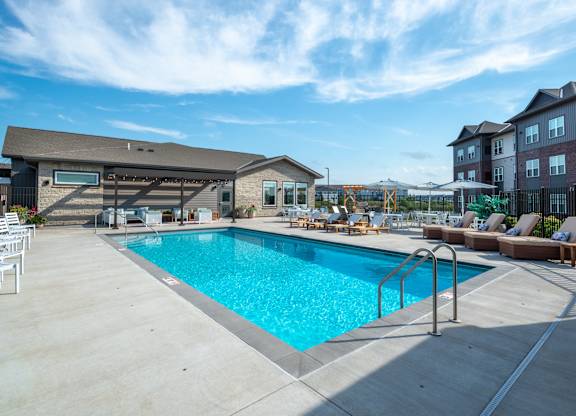 a swimming pool at a hotel with a blue sky above it
