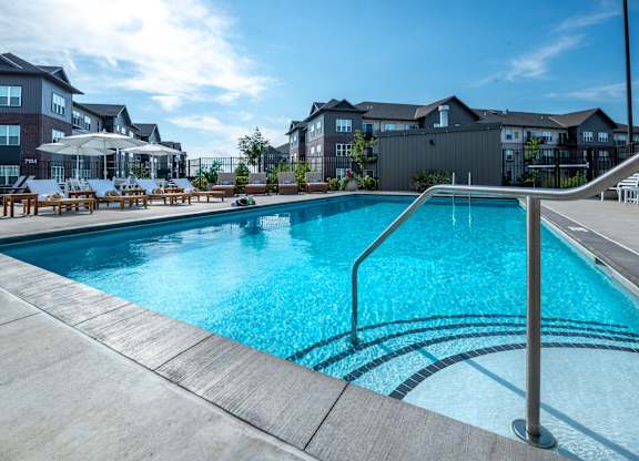 a swimming pool with apartment buildings in the background