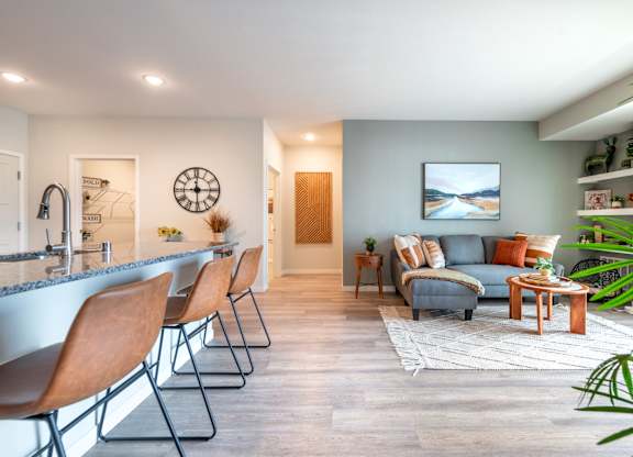 a living room and kitchen with a bar and a couch