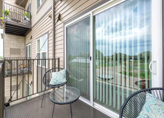 a patio with two chairs and a table on a balcony