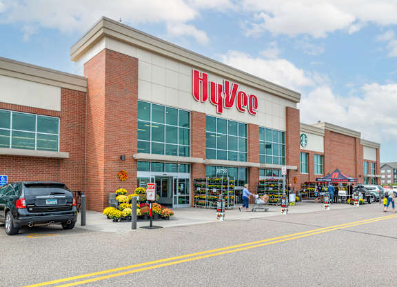 the exterior of a hoyo store with a car parked in front of it