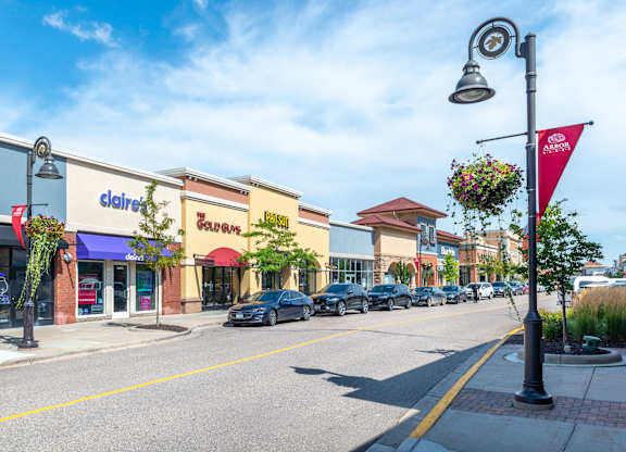 a city street with stores and cars parked on the side of the road