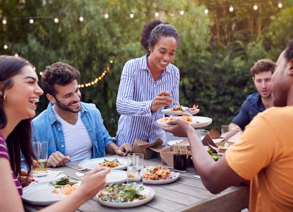 A group of people enjoying a meal together outdoors.