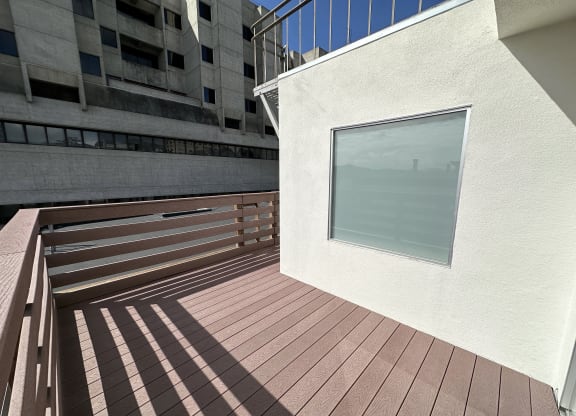 a large window in a white wall with a wooden deck